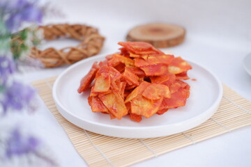 Keripik singkong balado or balado cassava chips on a serving plate, it tastes spicy, sweet and crunchy