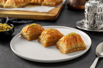 Delicious sweet baklava with pistachios on black table, closeup