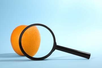 Cellulite problem. Zoomed orange peel on light blue background, view through magnifying glass. Space for text