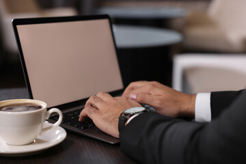 Man working on laptop at table in office, closeup