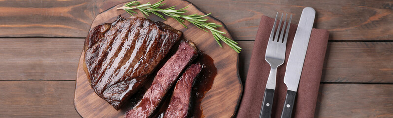 Delicious fried beef meat served on wooden table, flat lay. Banner design