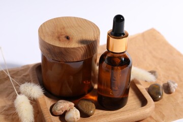 Composition with bottle of cosmetic serum on white background, closeup