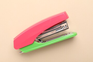 One bright stapler on beige background, top view