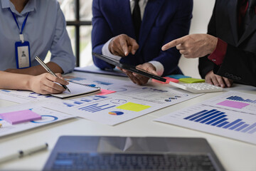 Team of business people working with Paperwork on a table in a conference room in a business presentation or seminar. The document contained financial or marketing figures, graphs, and charts with a l