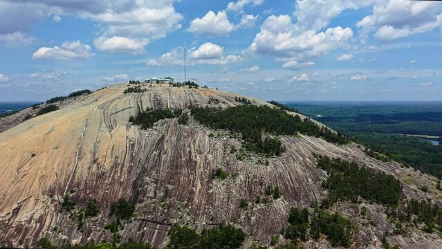 Aerial approaching shot of Stone Mountain park with granitic rock and landscape in background - Georgia, USA