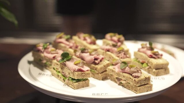 A plate finger foods, showcasing a variety of gourmet sandwiches at an elegant event buffet