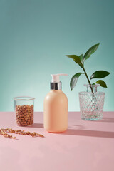 Unlabeled pump bottle in yellow color decorated with a beaker of soybeans against blue background. Cosmetic product advertising with empty label