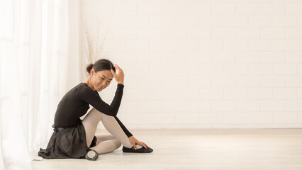 Asian ballet dancer relaxing in serene studio