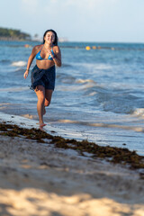 Vital woman running along the edge of the sea