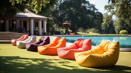 Relaxing bean bags laid out on shady grass for a contemporary outdoor event.