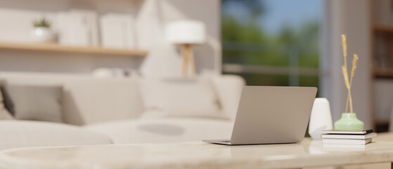 A laptop on a luxury white marble coffee table in a modern and comfortable living room.