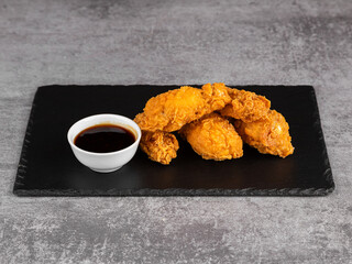 BBQ chicken wings close up on a wooden tray with selective focus. Fast food chicken wings with barbecue sauce