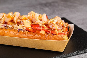 Gourmet grilled hot dogs with shrimp, sauce and peppers, onions and fries.Fresh tasty  Hot dogs