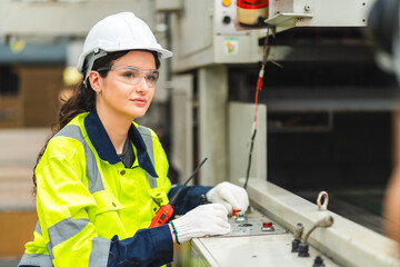 Portrait female professional engineer factory in protective uniform operating machine, Engineering worker in safety hardhat at warehouse industrial facilities, Heavy Industry Manufacturing