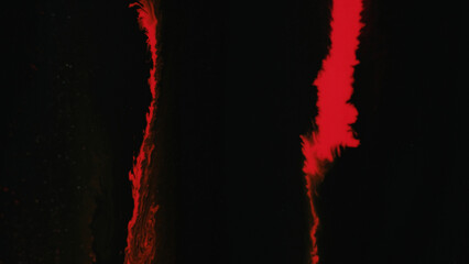 Paint drip. Ink pouring. Fluid mix. Red color dye spill flow mix wave motion on dark black art abstract grunge background with free space.
