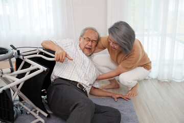 Obraz premium senior man fallen from wheelchair and senior woman helping him