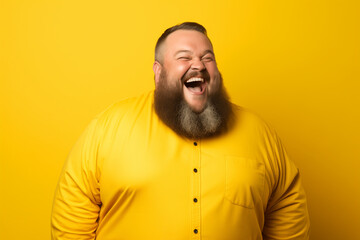 Obraz premium Fat bearded man in yellow clothes smiling on yellow background