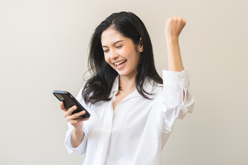 Happy asian young woman using mobile smart phone, read good news online feel excited getting offer,...