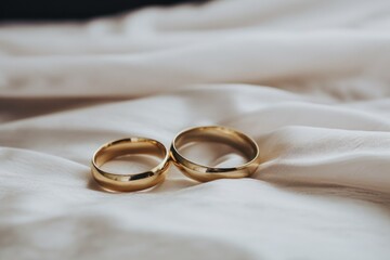 two gold rings on a white fabric