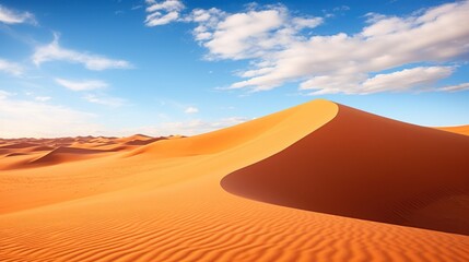 Fototapeta na wymiar a sand dune with blue sky and clouds