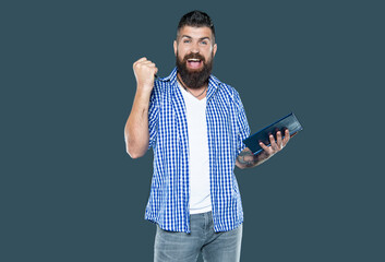 successful bearded man making notes in book on grey background