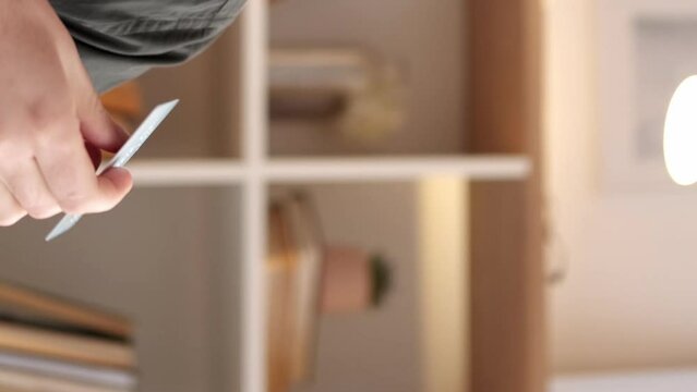 Vertical video. Banking consumer. Payment service. Happy dreamy man with credit card thinking of commerce shopping money account cashback saving at home.