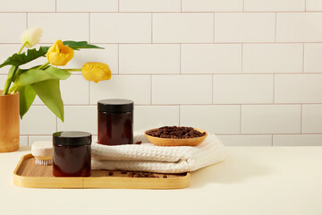 Front view of unlabeled amber cosmetic jar on wooden tray with coffee beans on tile ceramic...