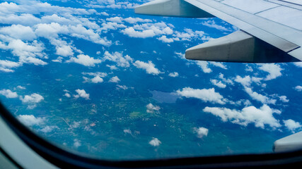 Aerial view of the sky and clouds through an airplane window. Travel concept. traveler, trip, vacation, tourism, landscape, vibrant, nature, scenery. Background