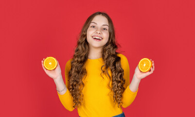 smiling teen girl hold orange fruit on purple background