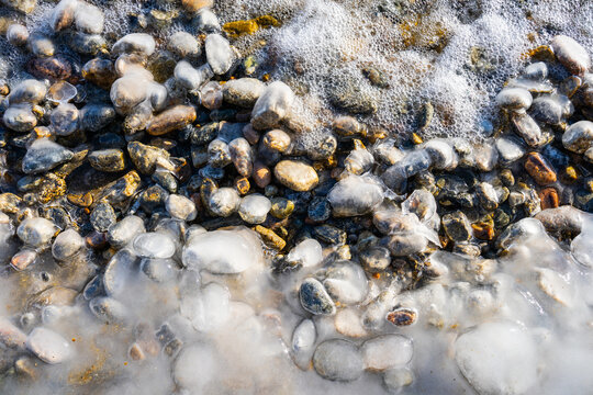 freezing rain caused icy glaze over decorate rocks. Stones in icy glaze. Background, texture. Selective focus.