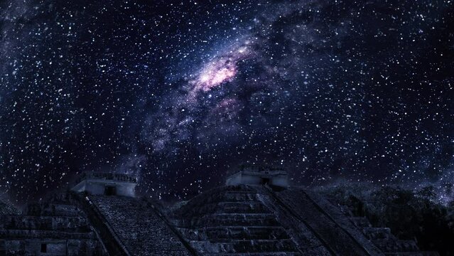 Milky way and stars in the night sky behind ancient pyramids.