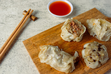 Dim sum with various fillings, from chicken, carrots, mushrooms and shrimp served with sauce.