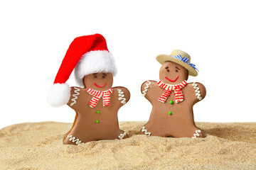 Funny gingerbread cookies on sand against white background. Christmas vacation concept