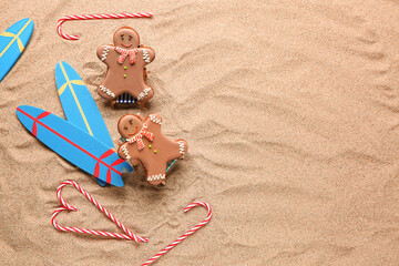 Fototapeta na wymiar Gingerbread cookies on mini deckchairs with surfboards and Christmas decorations on sand