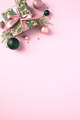 Christmas gift with ball ornaments on pastel pink background. Perfect for cards, invitations, and festive promotions. Merry Christmas and Happy New Year