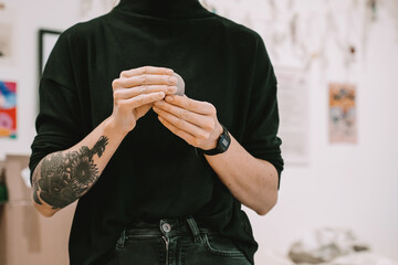 Female hands working with clay makes ceramic tableware on pottery workshop.