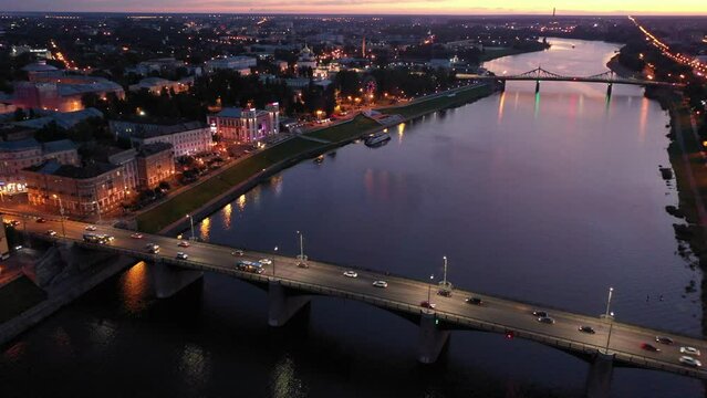 Scenic aerial view of Tver cityscape on banks of Volga river with bright illuminated embankment on summer twilight, Russia. High quality 4k footage