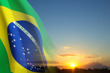 Flag of Brazil against the sunset. Patriotic background. Background for National holidays - obrazy, fototapety, plakaty