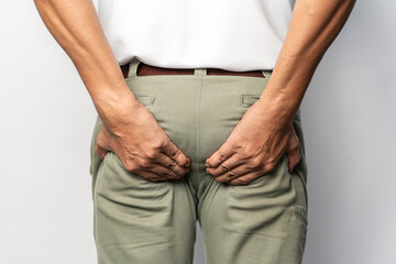 Man holding his butt in pain, isolated on gray. Man has Diarrhea Holding his Butt. Guy to hold with...