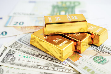 Gold bars with US dollar and Euro banknote money, finance trading investment business currency concept.