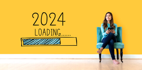 Loading new year 2024 with young woman holding a tablet computer - obrazy, fototapety, plakaty