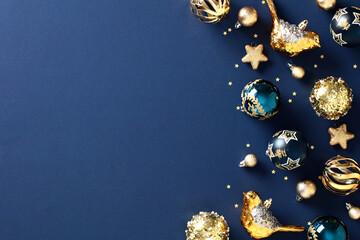 Christmas elegant navy blue background with golden Xmas balls ornaments. Stylish flat lay of festive decorations, glittering baubles, and a touch of vintage charm. Perfect for holiday cards, banners