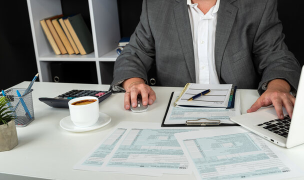 man completing tax form 1040. Tax time