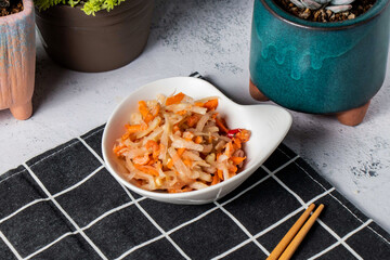 Cold green papaya served dish with chopsticks isolated on napkin side view of taiwanese food