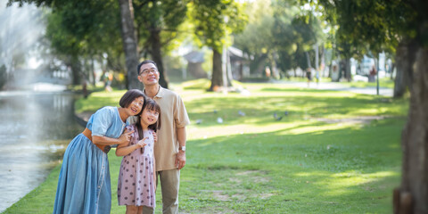 Grandparent playing togetherness with a granddaughter in the park in the morning. Family, love and...