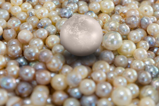 A pearl shaped earth standing on a pile of pearls  "Element s of this image furnished by NASA "