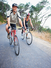 Happy couple, cycling and road in nature for, fitness, training or travel on bicycle together. Outdoor, people and exercise on bike for fun, workout and path in countryside for adventure or journey