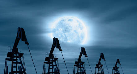 Silhouettes of oil pumps (pumpjack) with full moon at night 