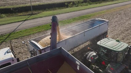 Semi Truck Trailer Being Filled With Grain Crop Harvest from a Grain Cart, Aerial