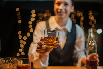 Bartender is pouring whiskey  glasses for customers beautiful night.